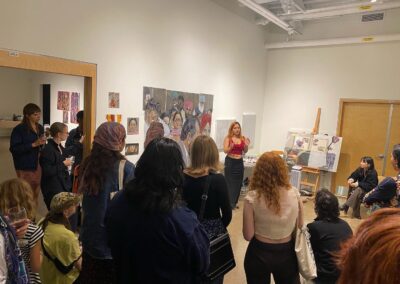 Various people looking at Meenakshi talking about her exhibition.